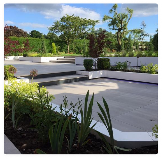 Modern landscaped garden with porcelain patio, steps and raised planting beds