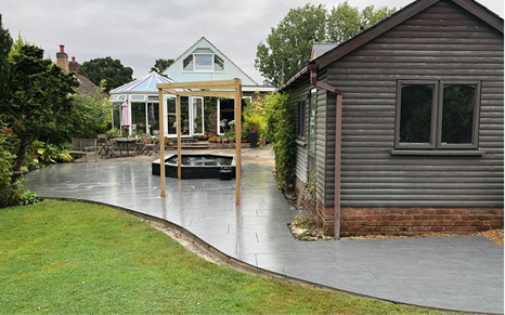 Block paved driveway with landscaped front garden and decorative edging