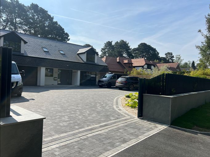 Block paved driveway with landscaped planting and modern garden edging