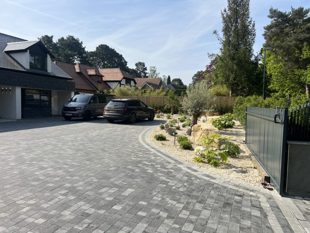 Block paved driveway with decorative edging and landscaped front garden
