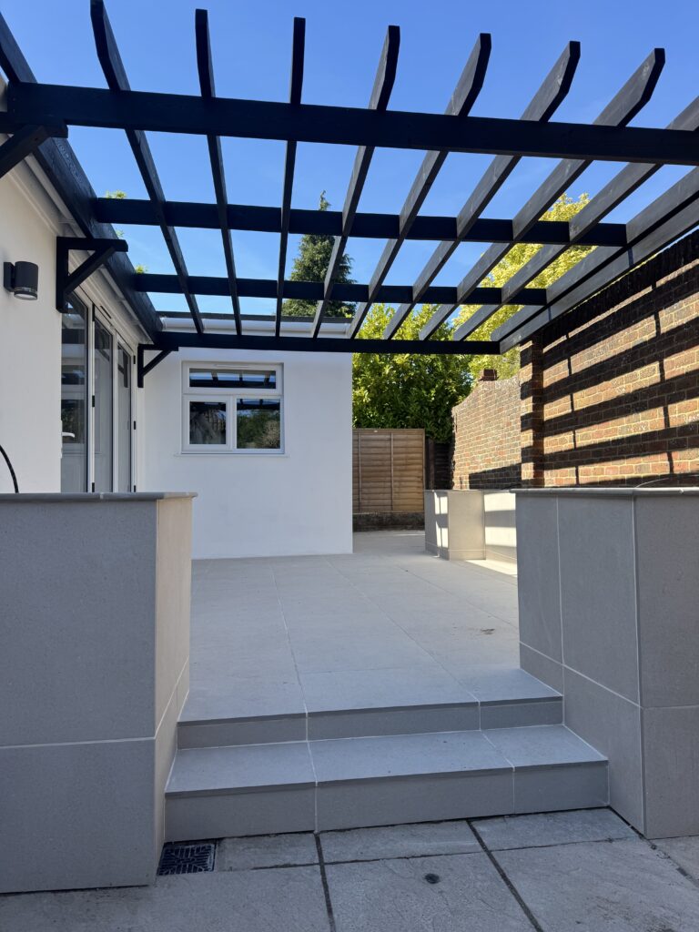Porcelain patio and pergola extension by Classic Landscaping, Poole
