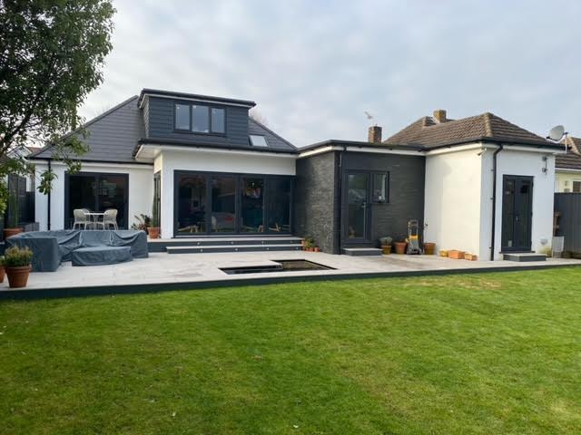 Lawn and porcelain patio behind a modern extended home