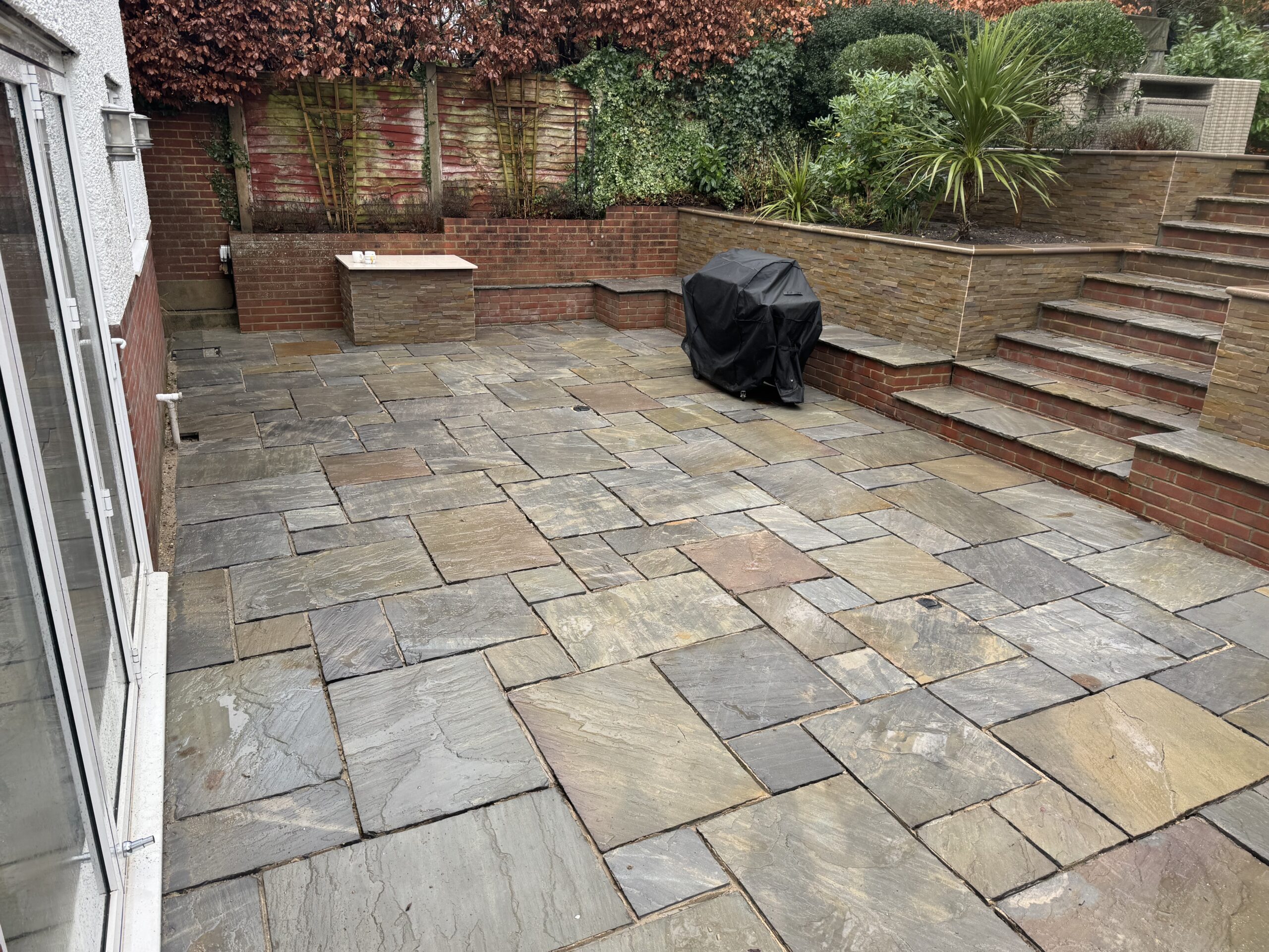 Natural stone patio with raised stone walls and steps